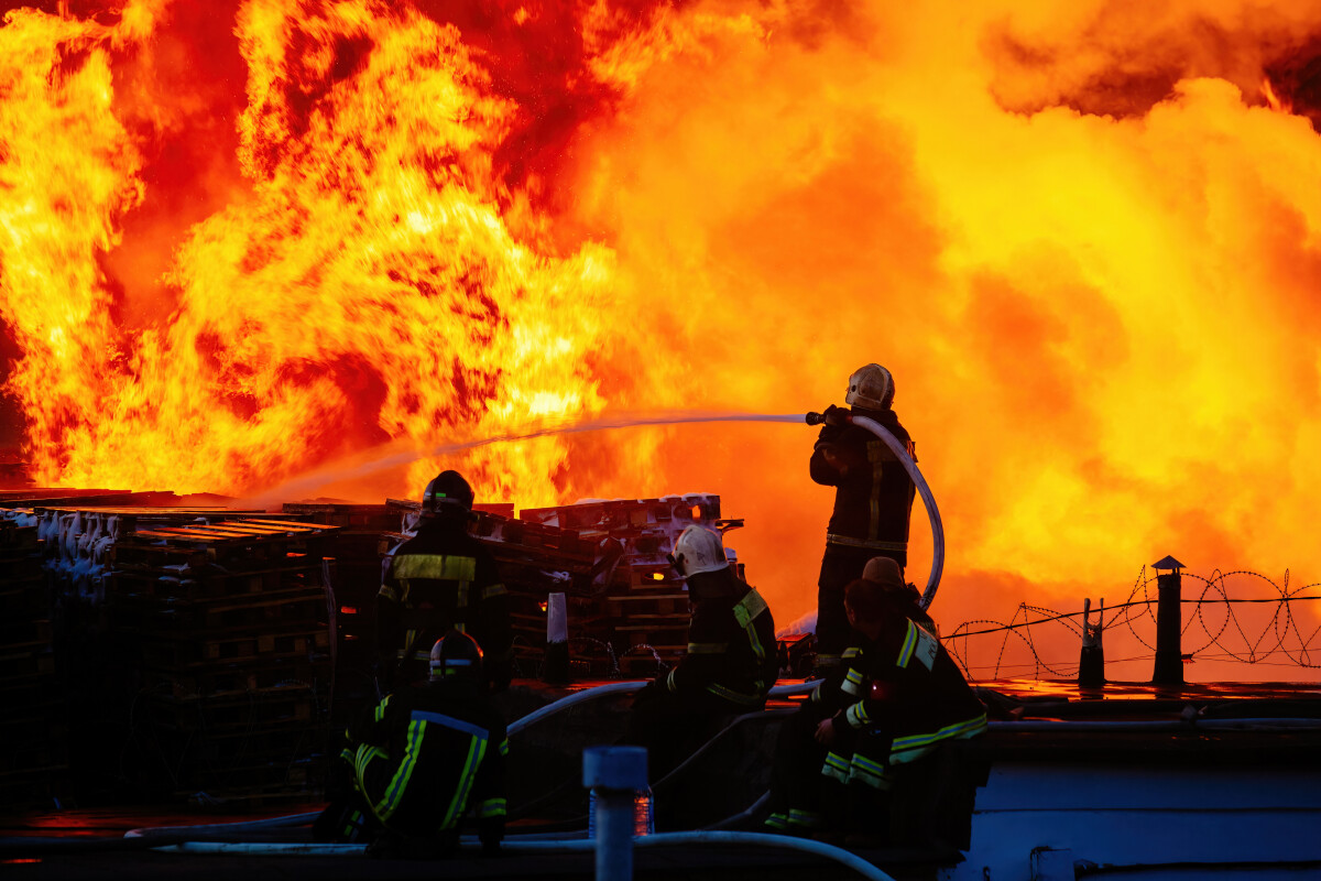 Team of firefighters extinguish burning industrial building in the city