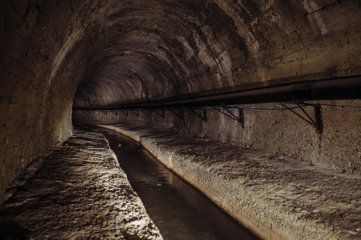 Underground vaulted urban sewer tunnel with dirty sewage