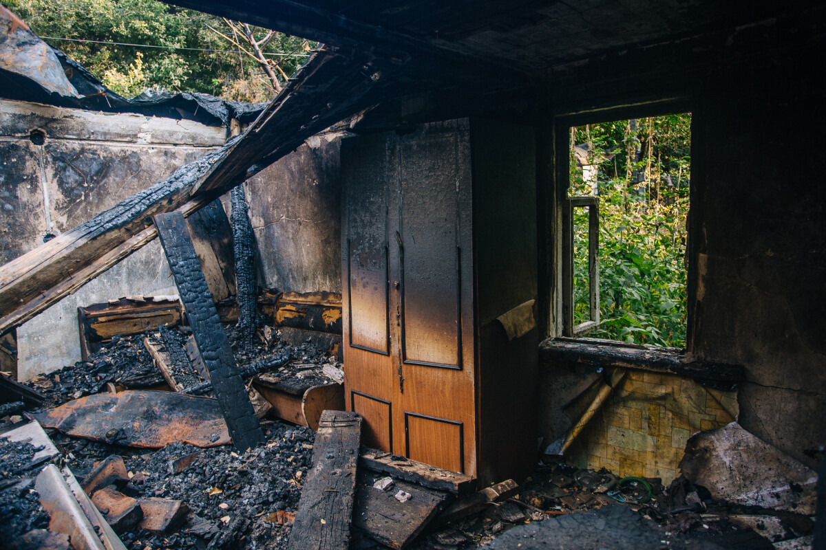 Fire aftermath. Burnt wooden house interior with remnant of furniture