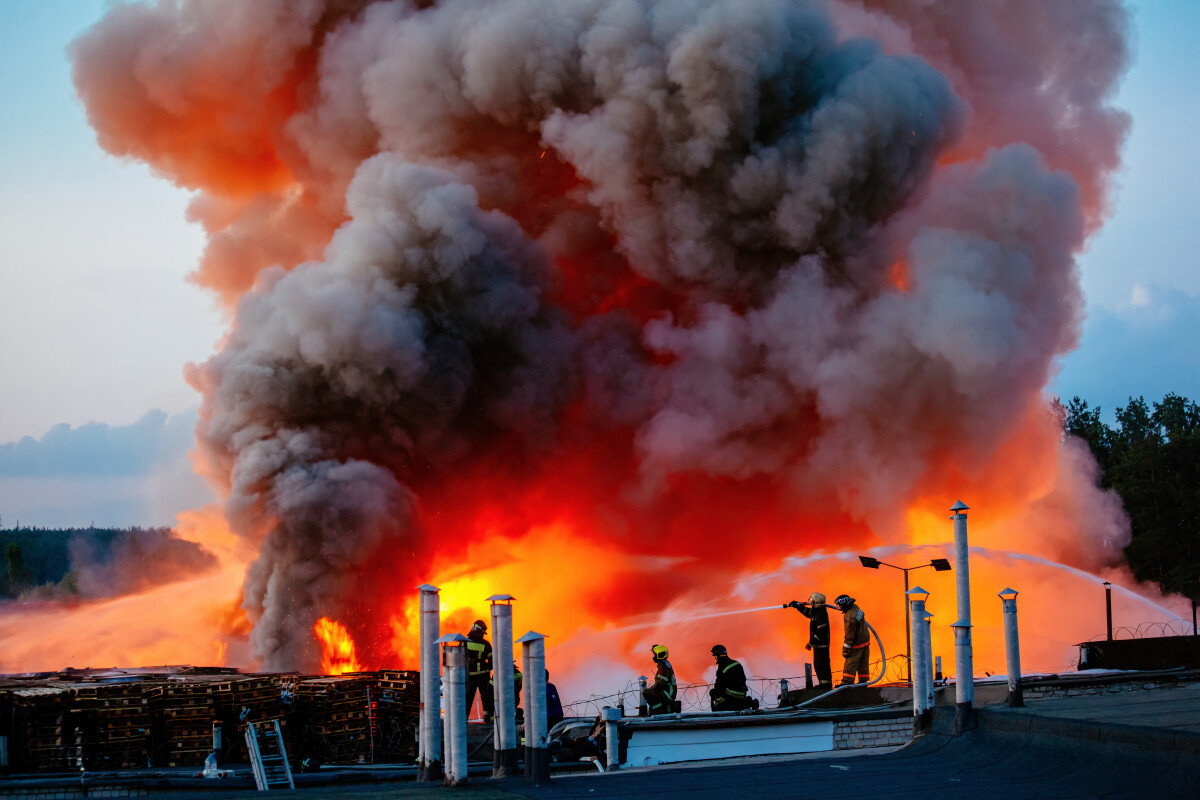 Firefighters extinguish burning industrial building in the city