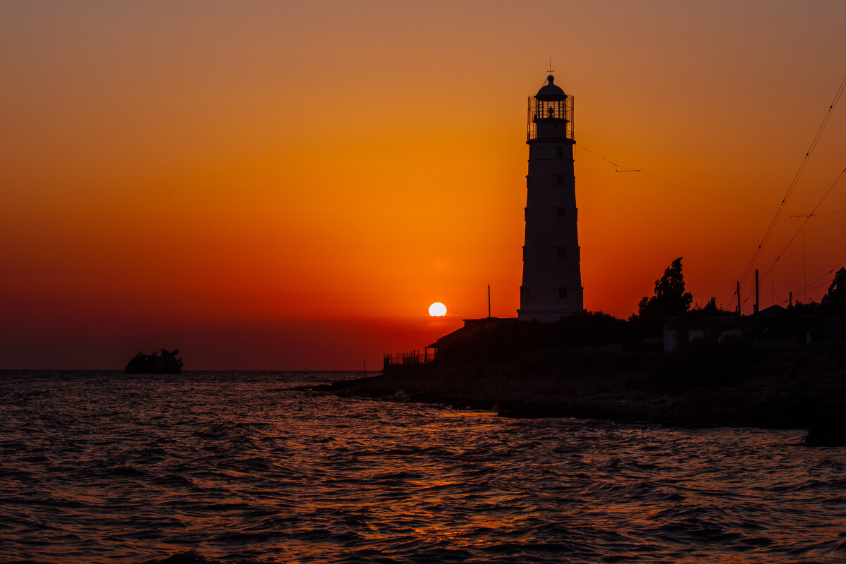 Lighthouse on the sea coast at sunset