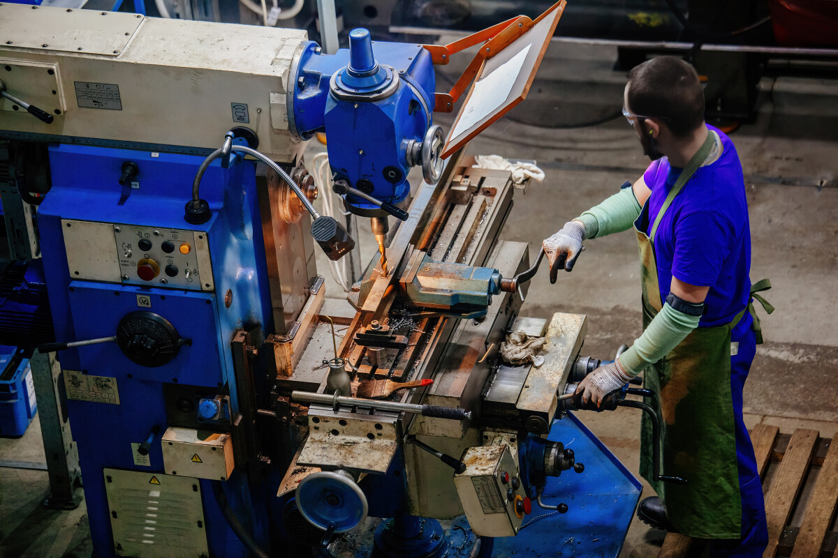 Industrial worker operating drilling machine