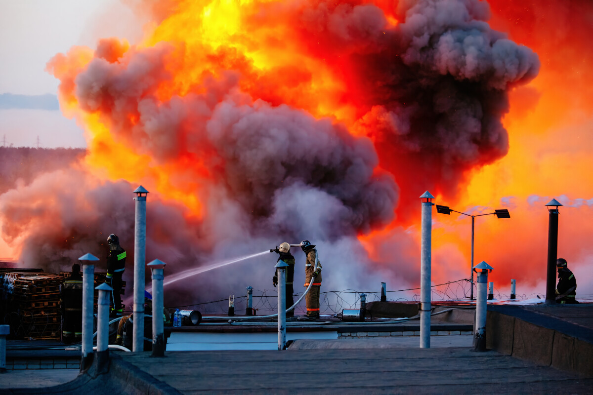 Firefighters extinguish burning industrial building in the city