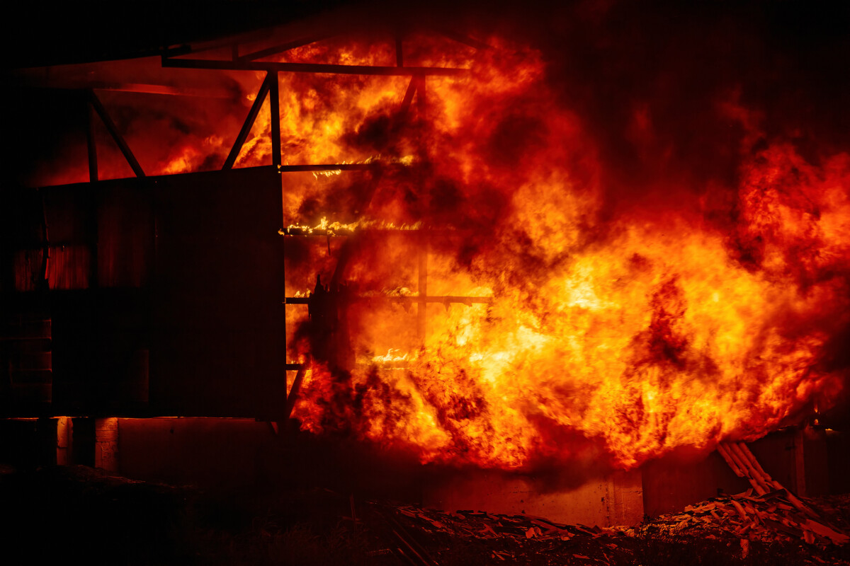 Exploding warehouse. Burning industrial building. Big blaze at night