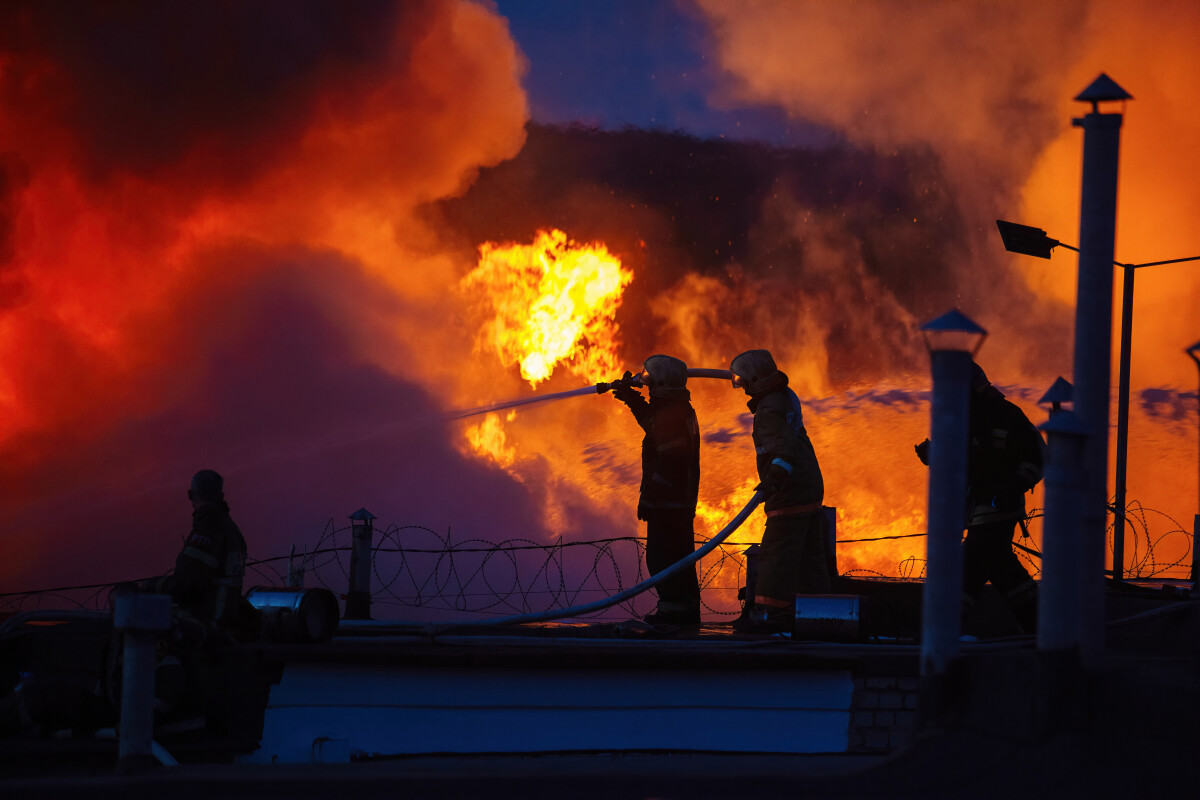 Team of firefighters extinguish burning industrial building in the city