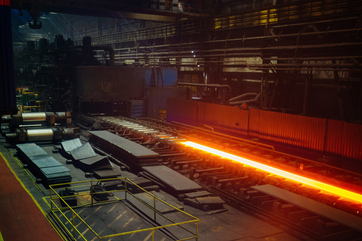 Rolled metal factory. Hot iron slab moving on conveyor of metal rolling mill