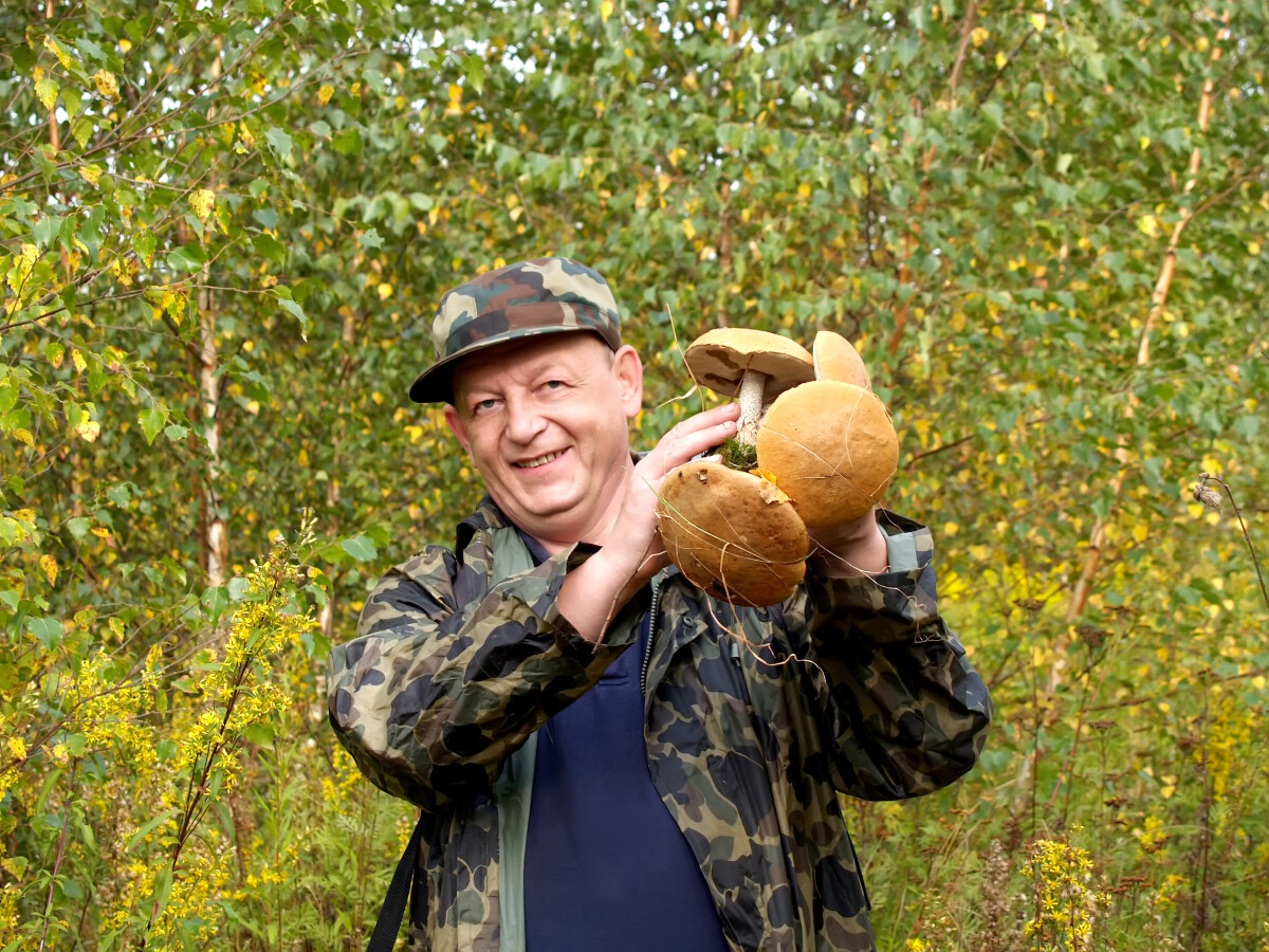 Веселый человечек держит в руке грибы (фокус на грибах)