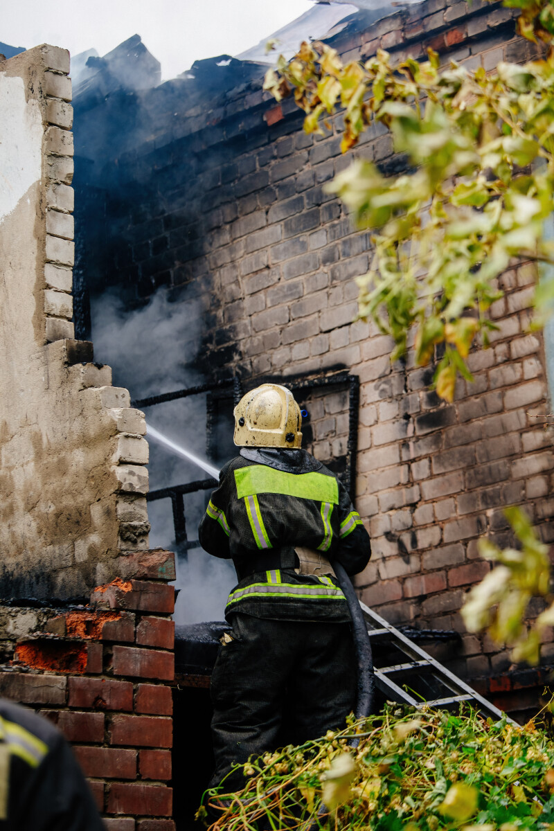 Firefighter extinguish fire in house using spraying hose