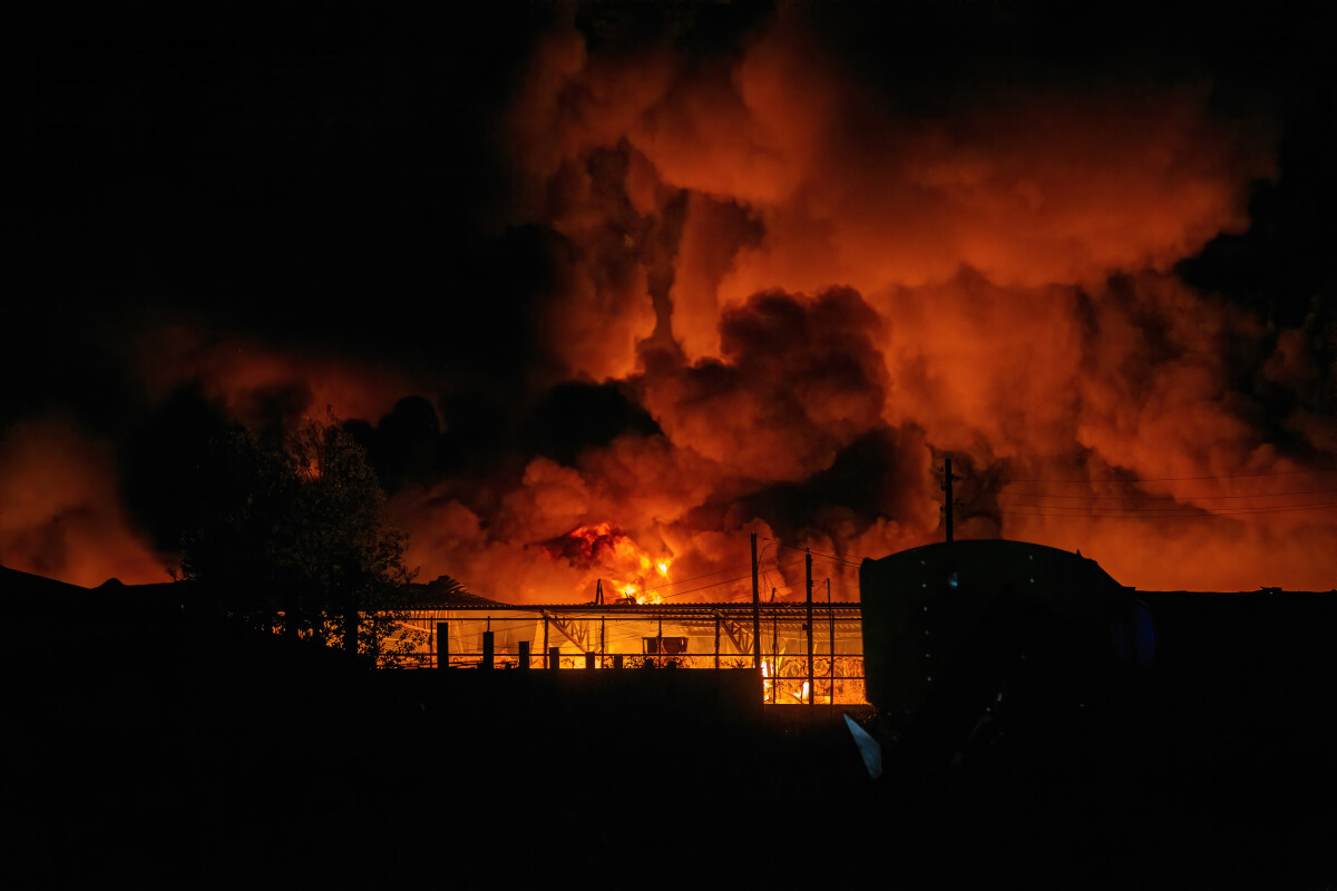 Burning industrial building. Big blaze and smoke at night