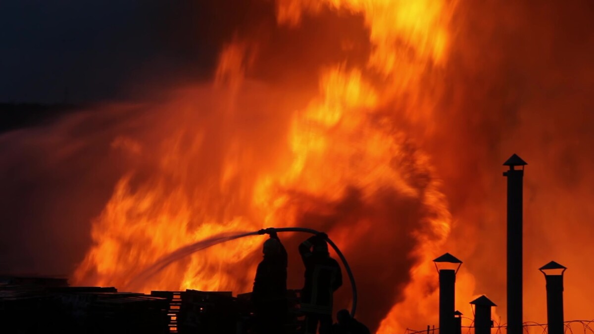 Firefighters extinguish burning industrial building in the city