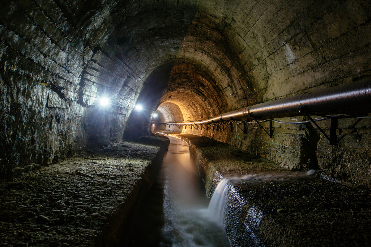 Underground vaulted urban sewer tunnel with dirty sewage