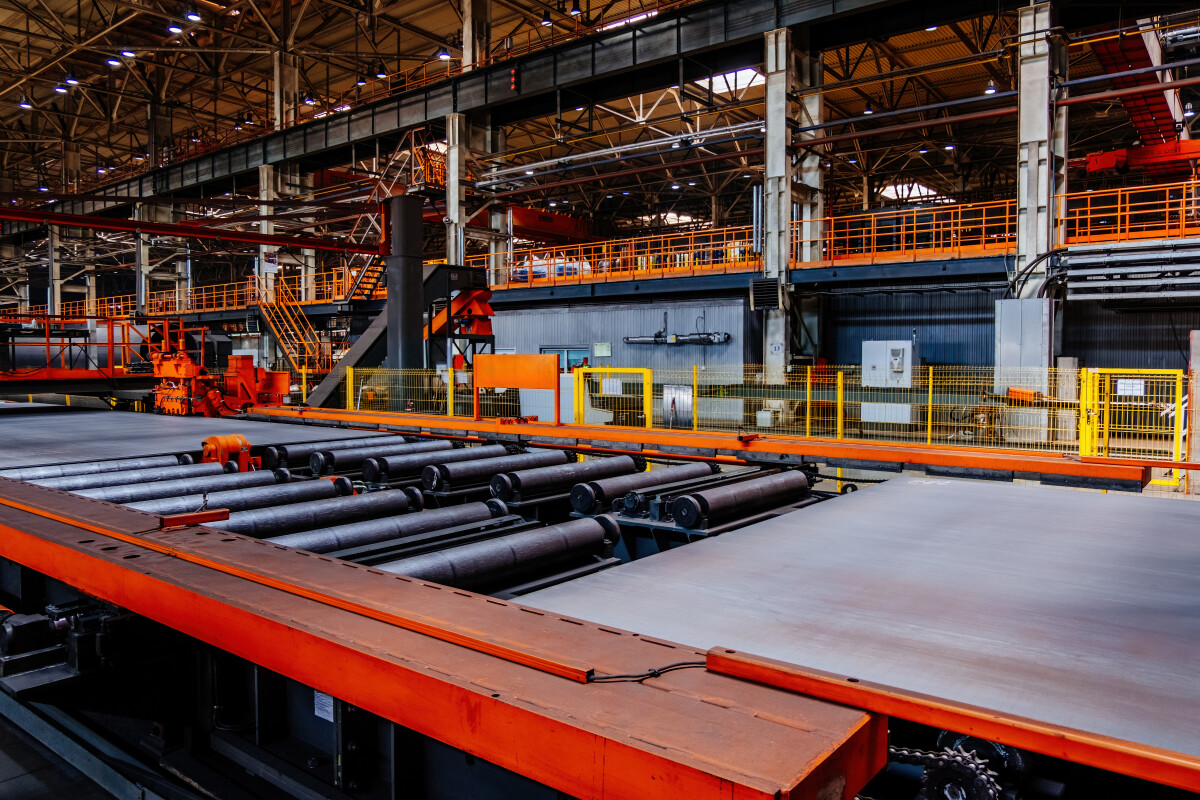 Steel sheet moving on roller conveyor in metalworking workshop