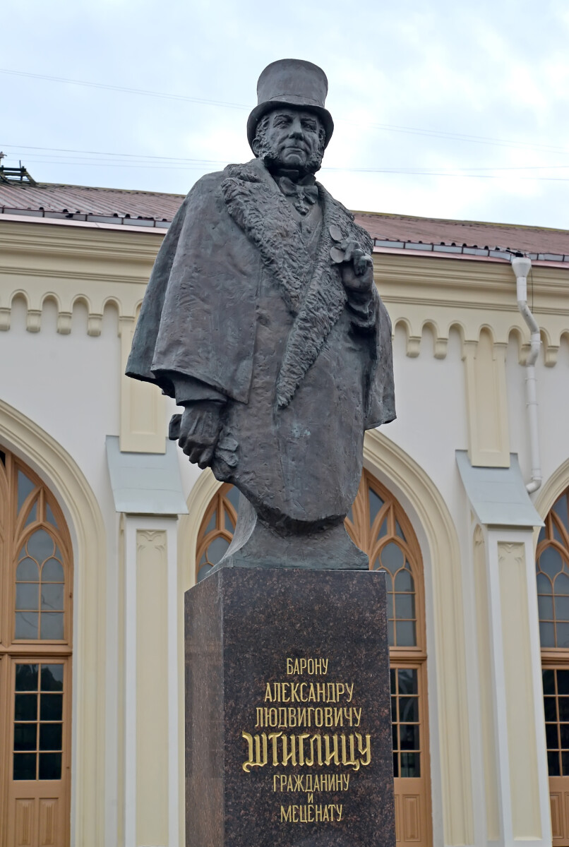 Памятник барону Александру Людвиговичу Штиглицу на фоне железнодорожного вокзала станции Новый Петергоф