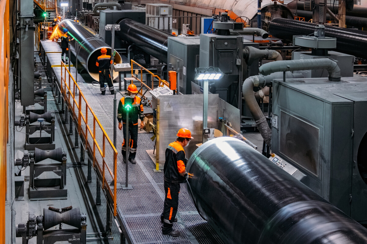 Engineers inspecting pipe factory production line