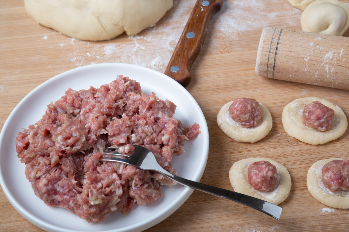 Процесс приготовления домашних пельменей. Мясной фарш на тесте. Русская кухня