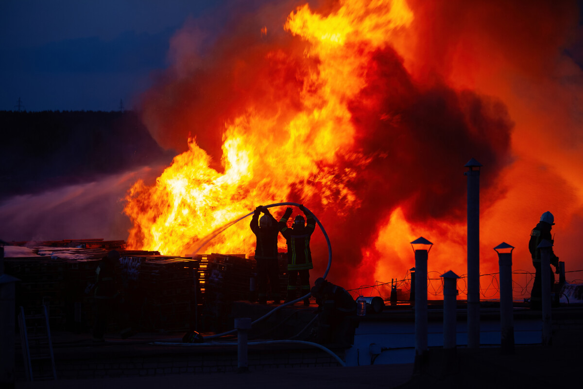 Firefighters extinguish burning industrial building in the city