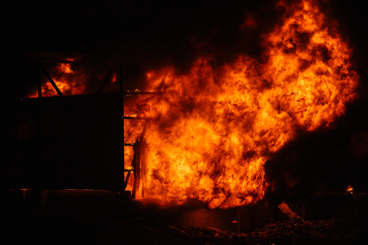 Exploding warehouse. Burning industrial building. Big blaze at night