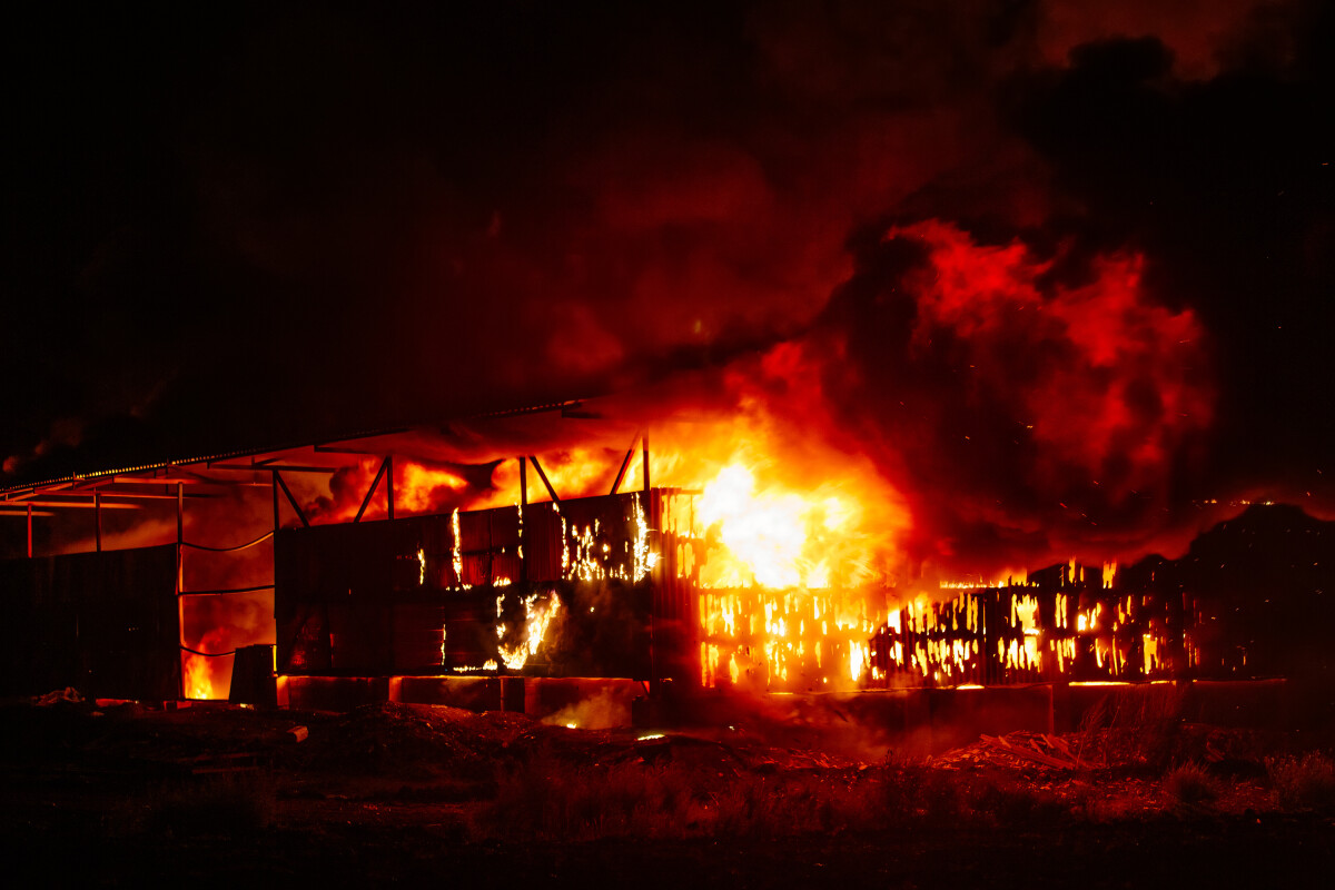 Exploding warehouse. Burning industrial building. Big blaze at night