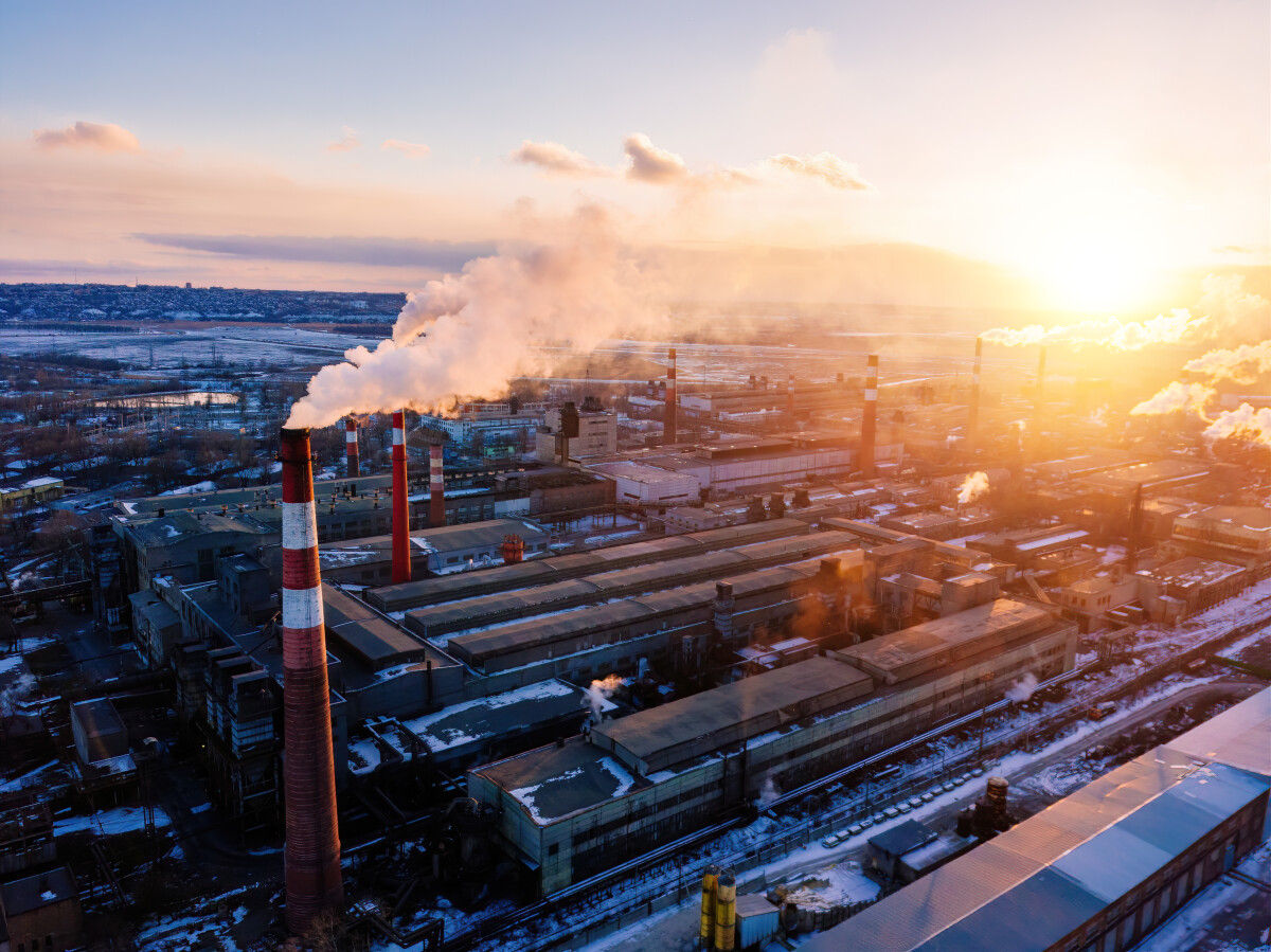 Industrial landscape at the sunset, aerial view. Smoke coming out from factory chimneys