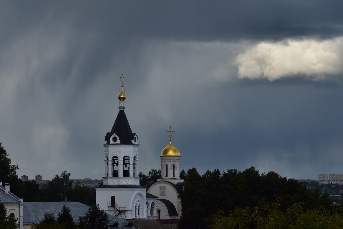 Православный храм на фоне темного пасмурного неба