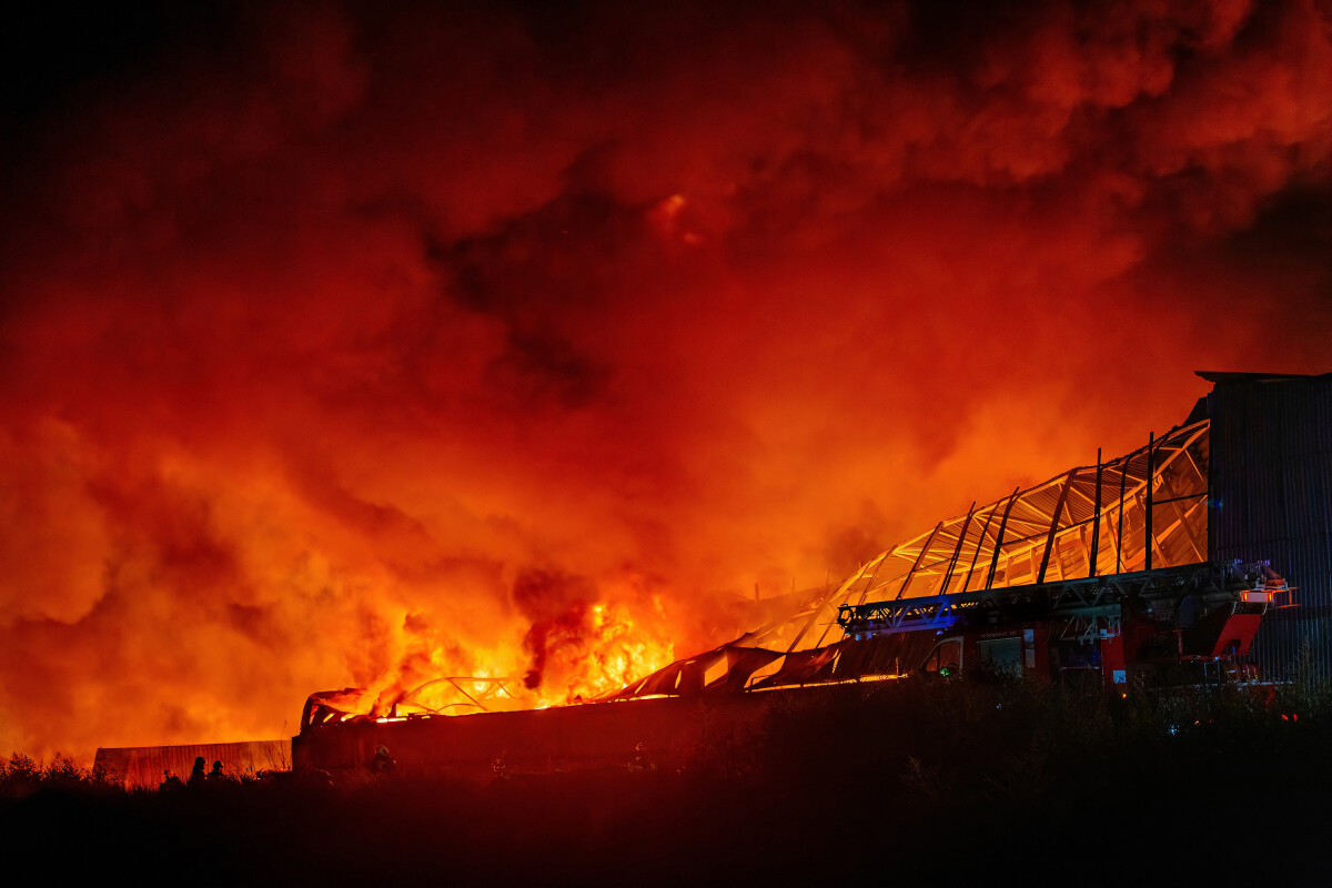 Burning industrial building. Big blaze at night.