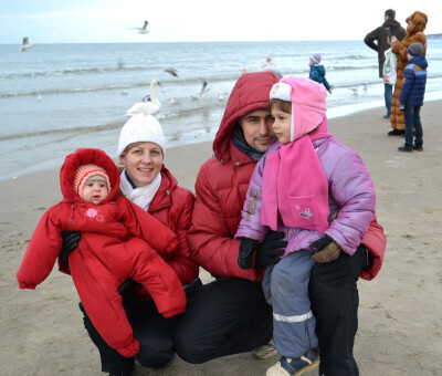 Молодая дружная семья с двумя маленькими детьми на берегу Балтийского моря