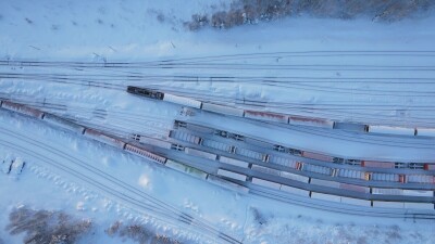 Вид с воздуха на железную дорогу и поезда зимой