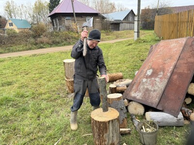 Деревня. Дед в валенках колет дрова.