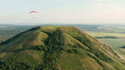 Южный Урал, мотопараплан пролетает над горой Торатау. Вид с воздуха.